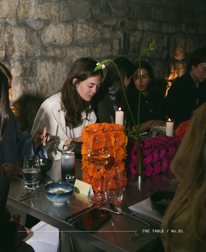 Dinner Table with people eating and a LEAU NIGHT on the table with floral decor.