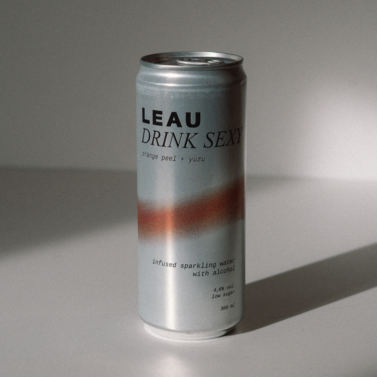 Silver can with 'LEAU DRINK SEXY' text on a gray background