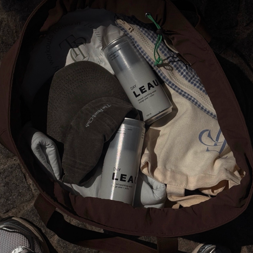 Two cans of LEAU DAY product in a brown bag with clothes.