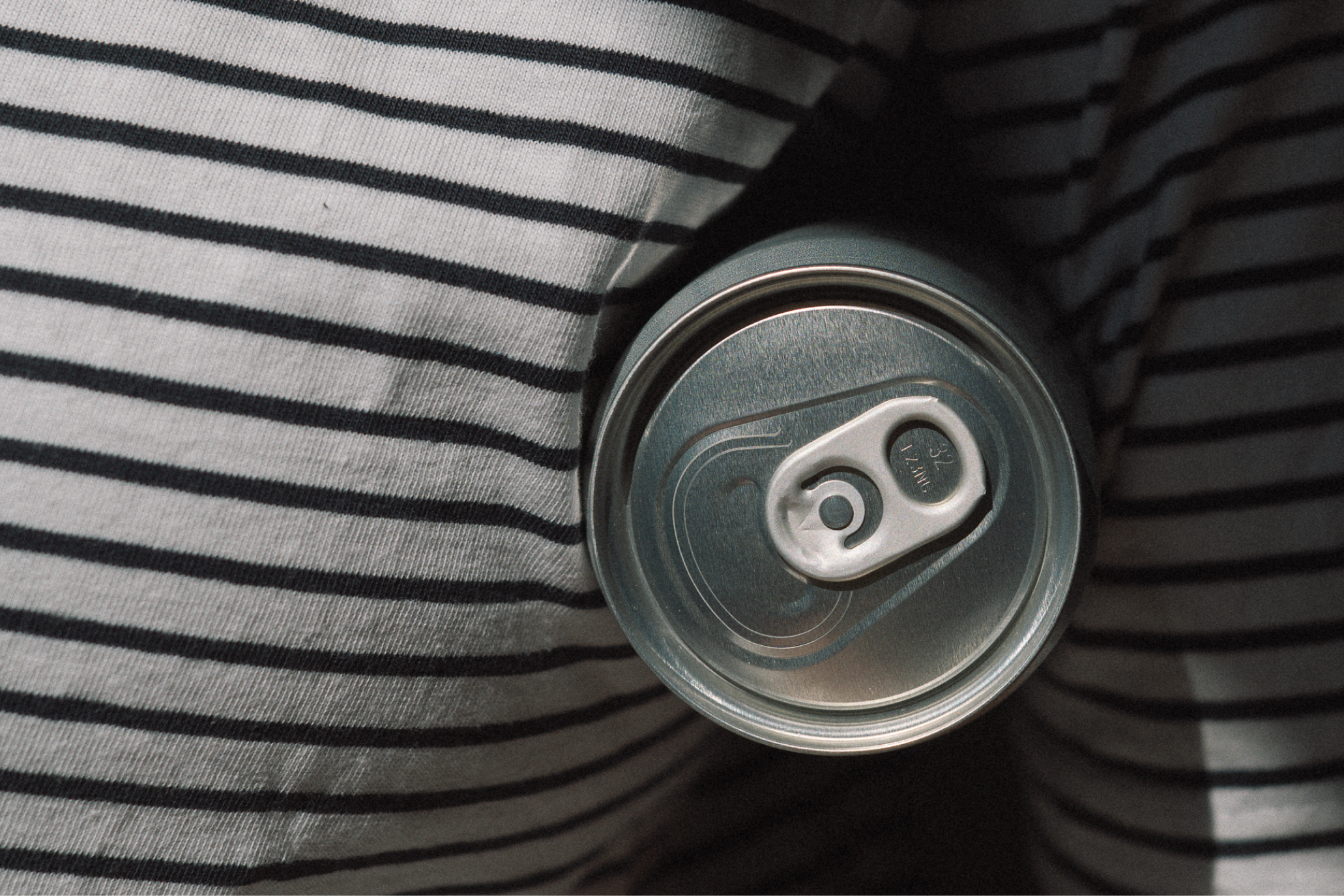Close-up of a can of LEAU on a striped fabric surface
